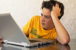 Teen boy using laptop computer
